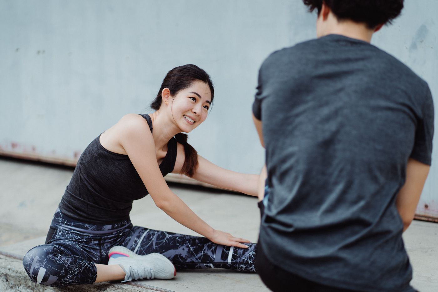 Two friends stretching together after a workout